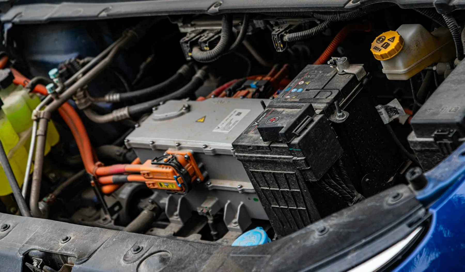 Electric vehicle engine bay with power electronics and orange high-voltage cables